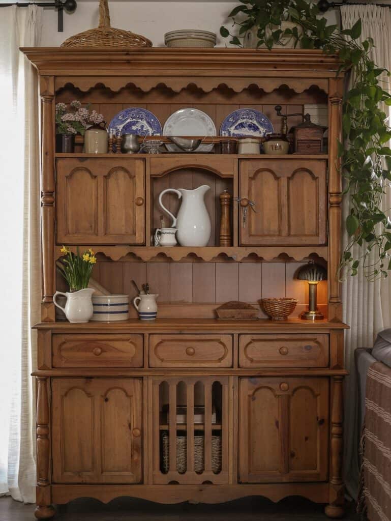 Rustic wooden hutch with dishes, plants, and decorative items for home decor.