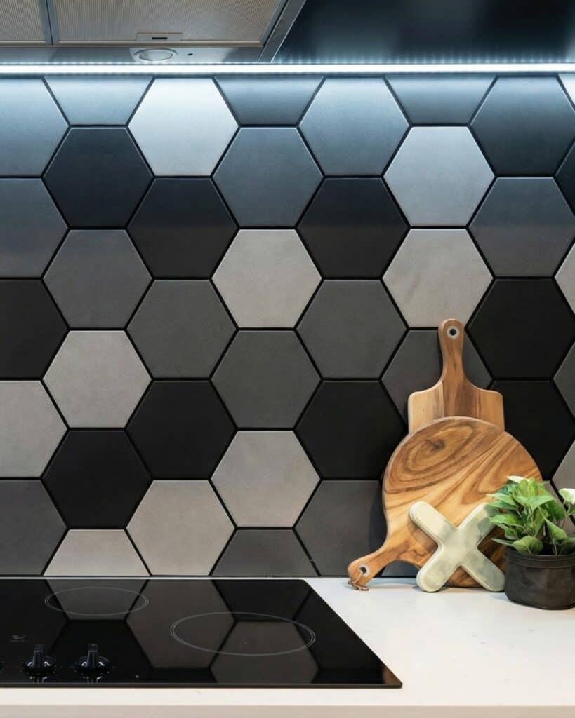 Contemporary kitchen backsplash with black, gray, and white hexagon tiles.