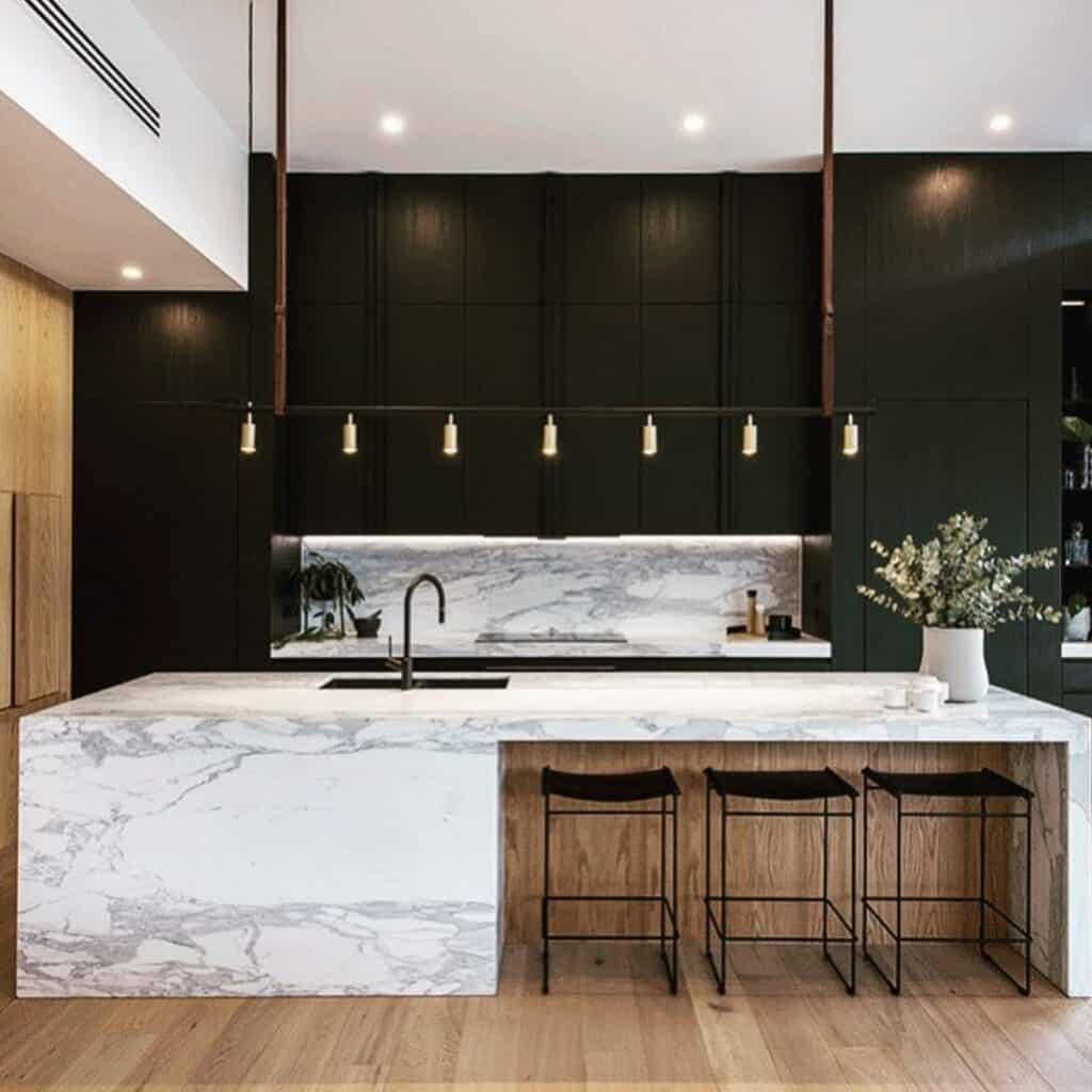 Contemporary kitchen with black cabinets and marble island for bold style.