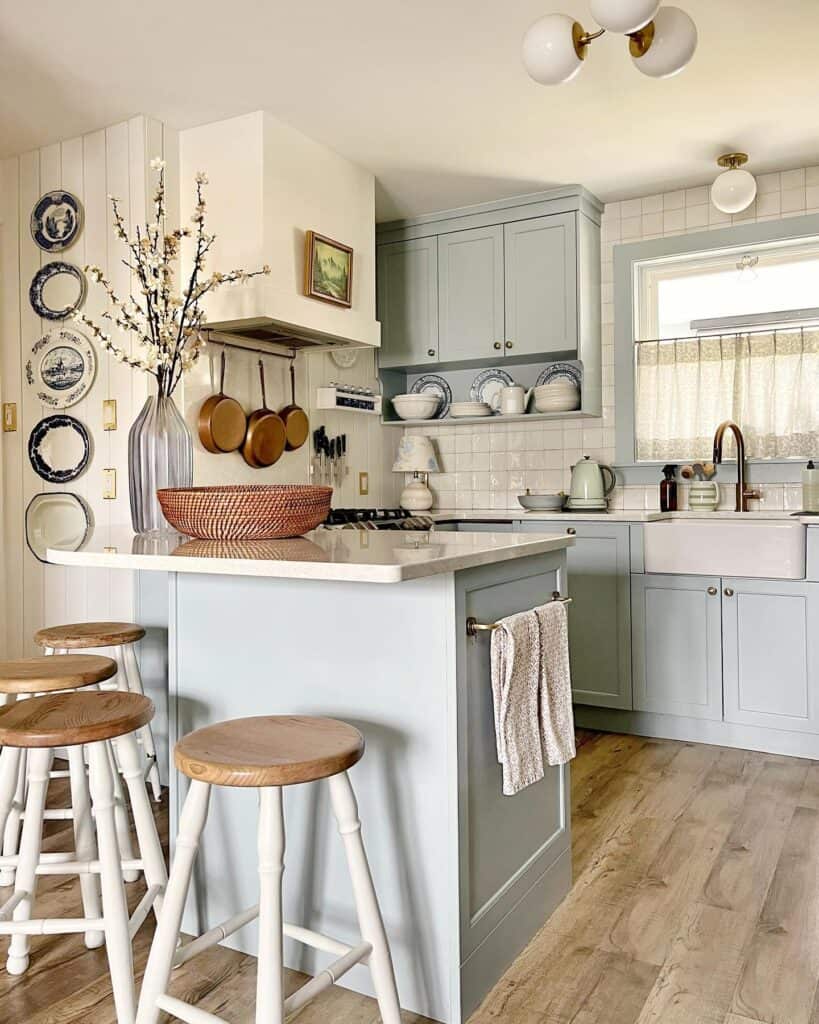 Kitchen with pastel blue cabinets, white backsplash, and wooden accents.