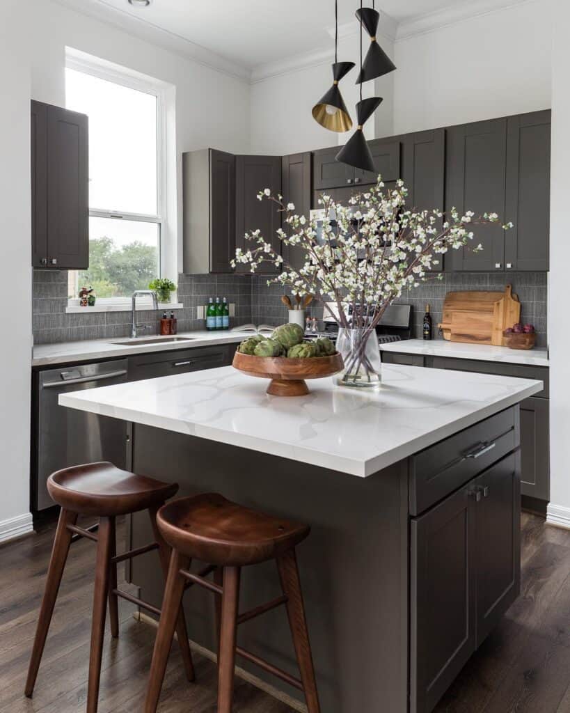 Contemporary kitchen with dark cabinets, white island, and floral centerpiece.