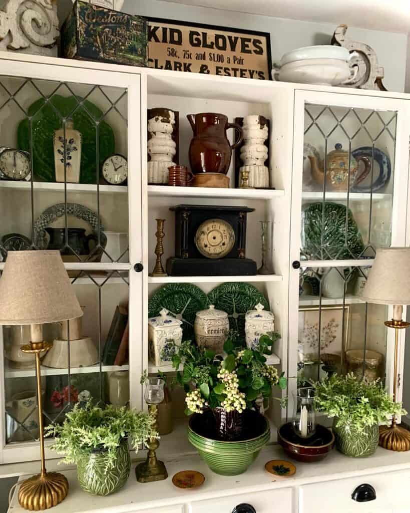 Decorative vintage hutch with plants, lamps, and collectibles for home styling.