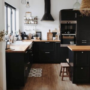Modern black kitchen cabinets with wooden countertops and stainless steel appliances.