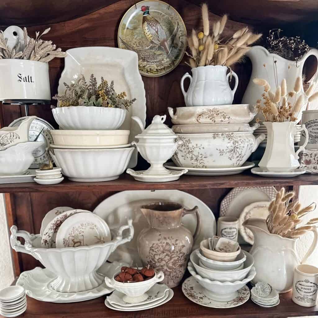 Elegant vintage white ceramic dishware and decorative pieces on wooden shelves.