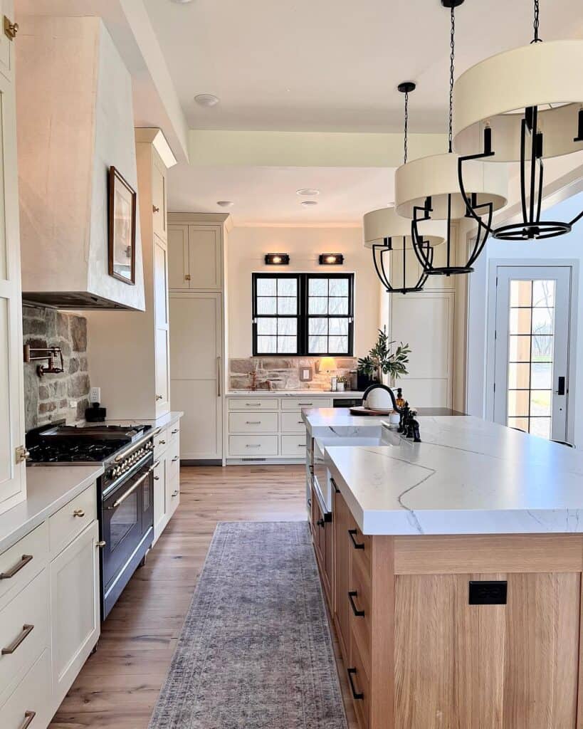 Bright kitchen with white cabinets, wooden island, and black fixtures for a cozy feel.