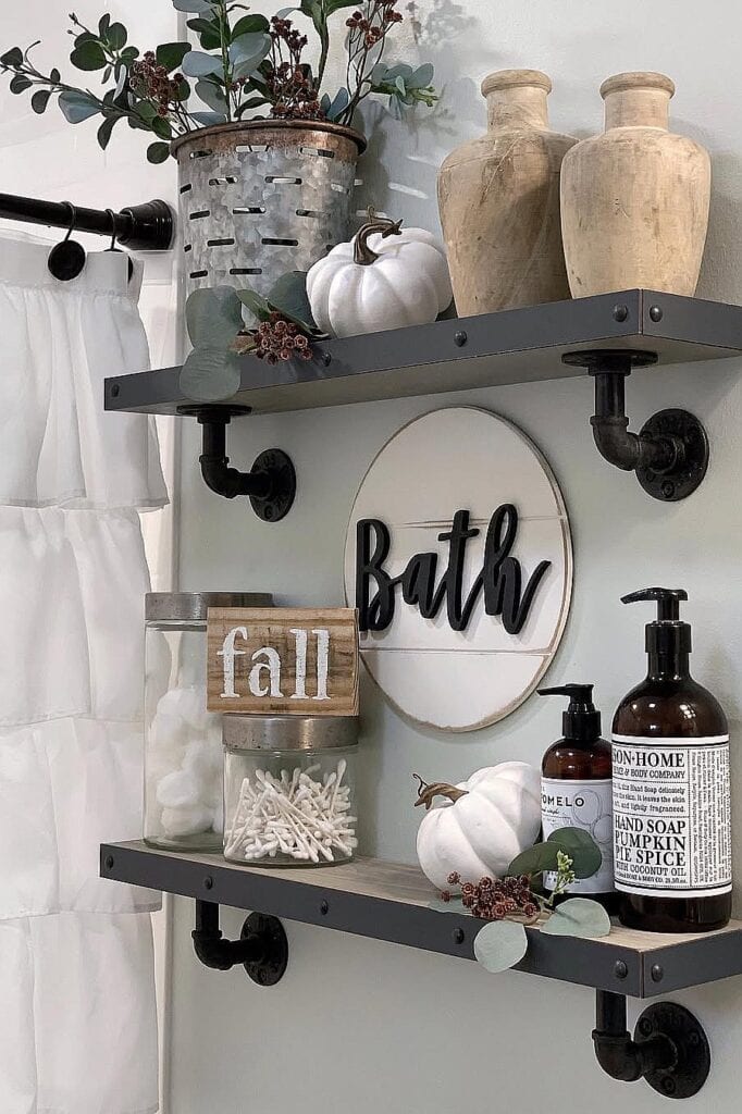 Autumn-themed bathroom shelf decor with pumpkins, vases, and fall accents.