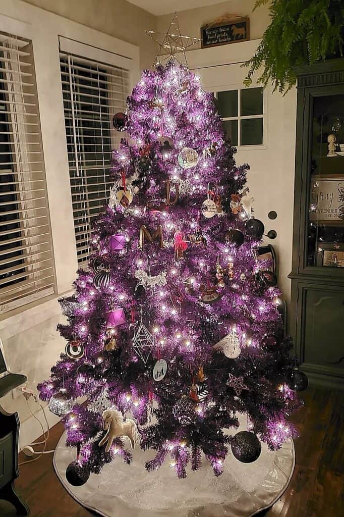 Beautiful purple Christmas tree decorated with ornaments and lights for holiday decor.