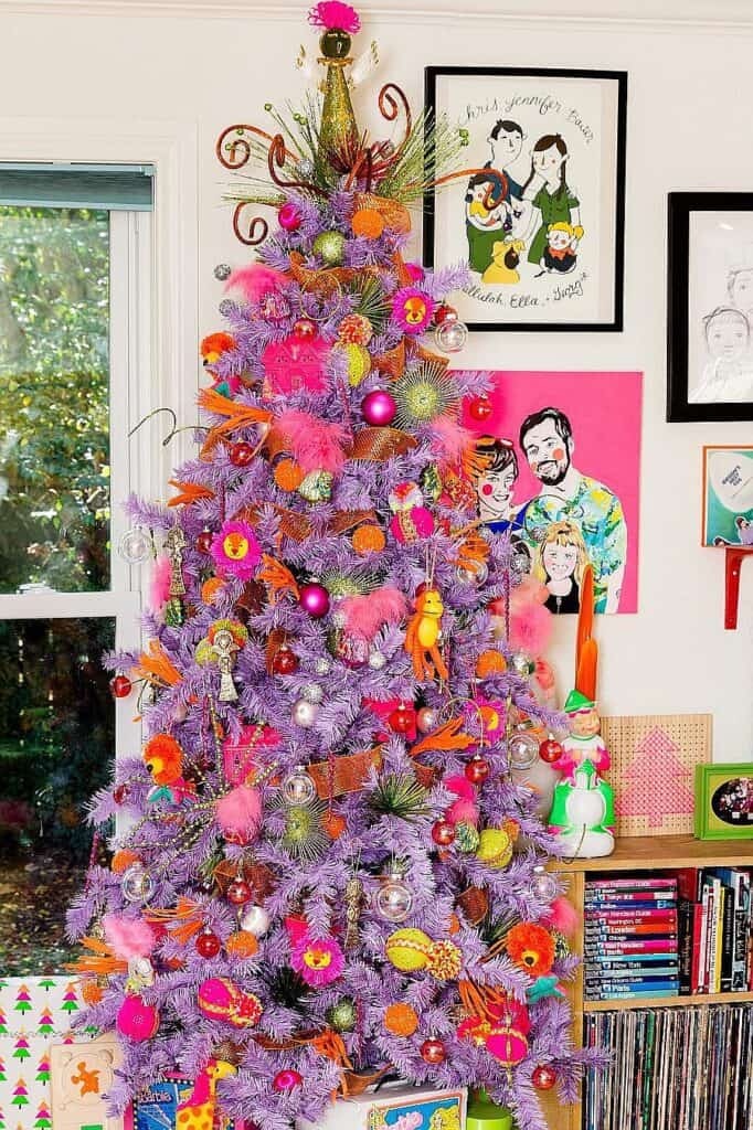 Colorful purple Christmas tree decorated with pink, orange, and yellow ornaments and ornaments.