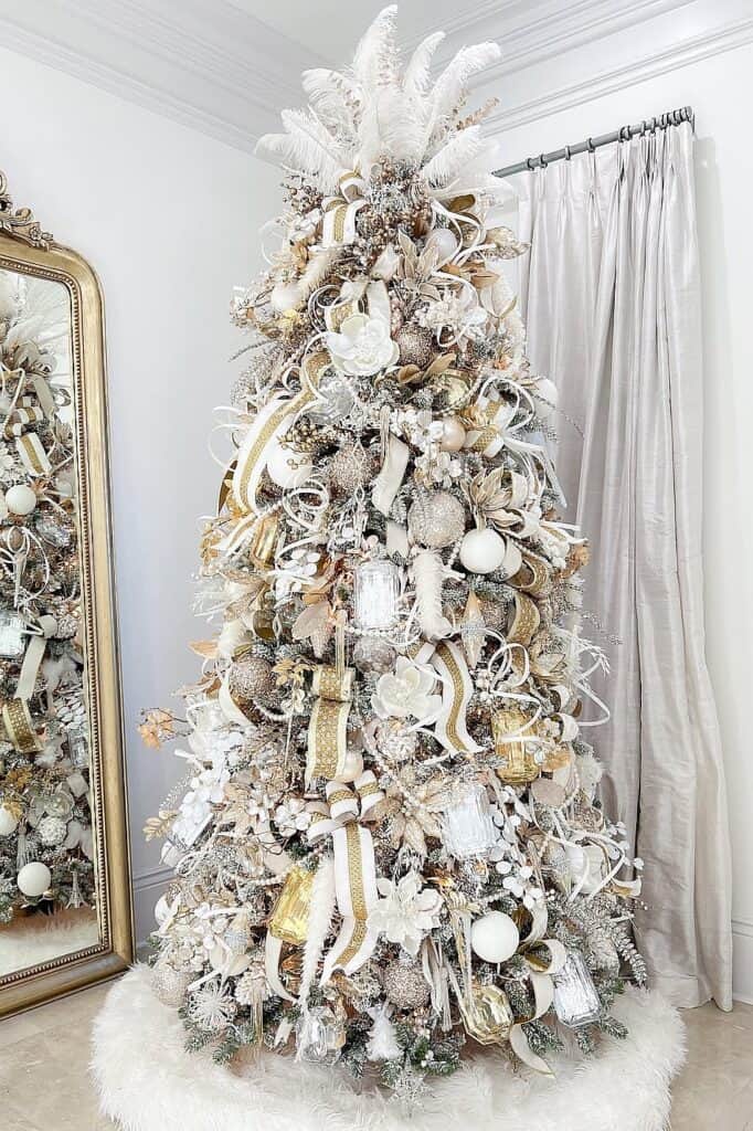 Beautiful white Christmas tree with gold and silver ornaments and ribbons.
