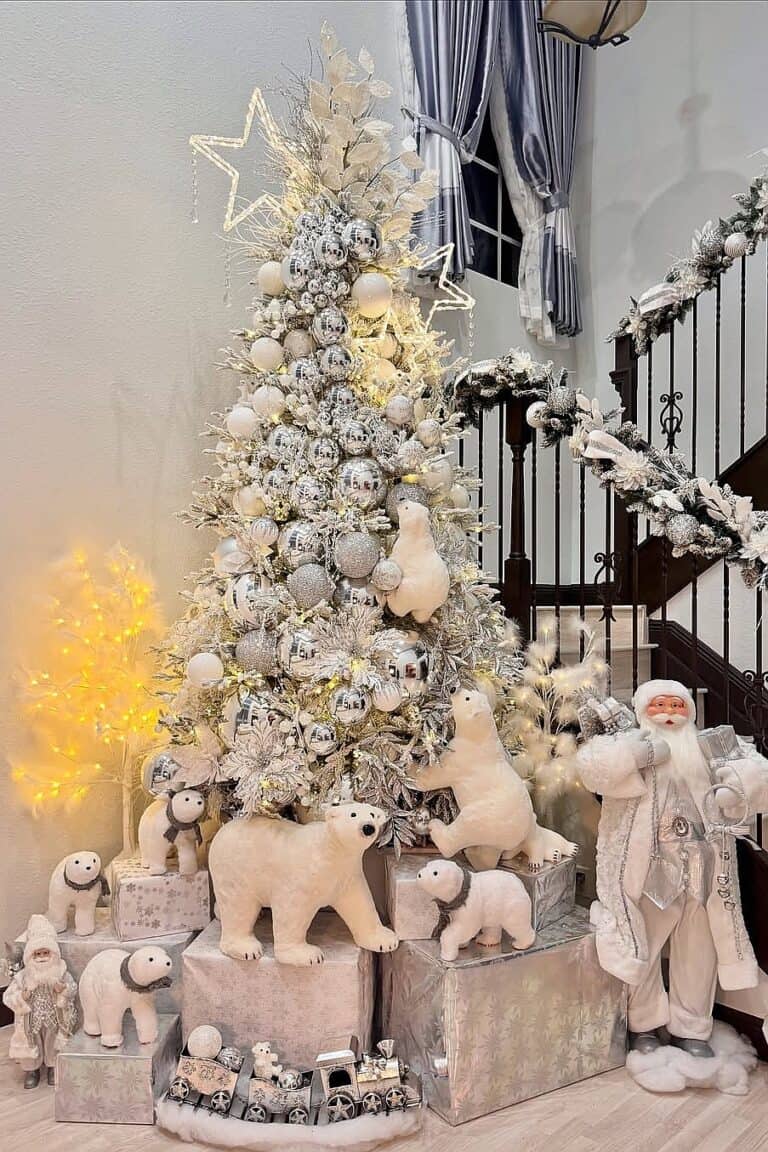Beautiful white Christmas tree with ornaments, plush animals, and snow-themed decorations.