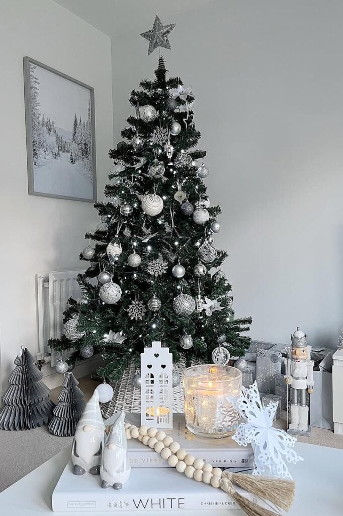 White Christmas tree with silver ornaments and holiday decorations.