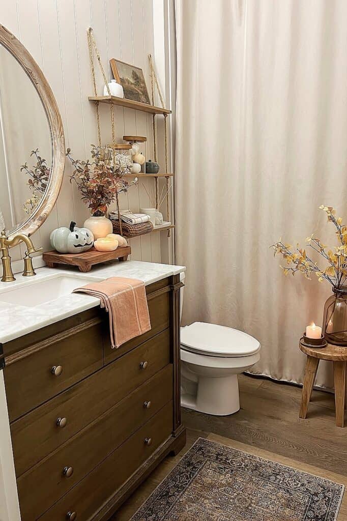 Cozy fall-themed bathroom with pumpkins, candles, and autumn accents.