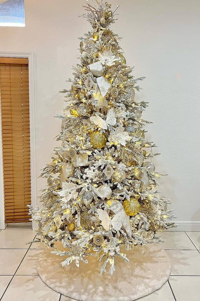 Beautiful white Christmas tree with gold and white ornaments and lights.