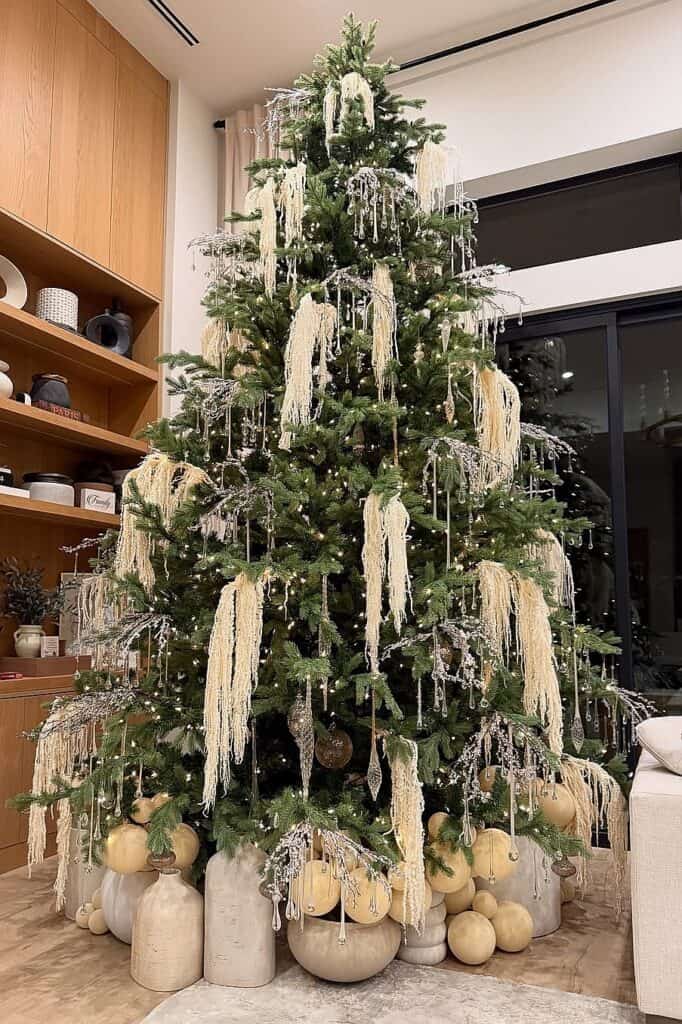 Beautiful white Christmas tree with hanging ornaments and neutral decor.
