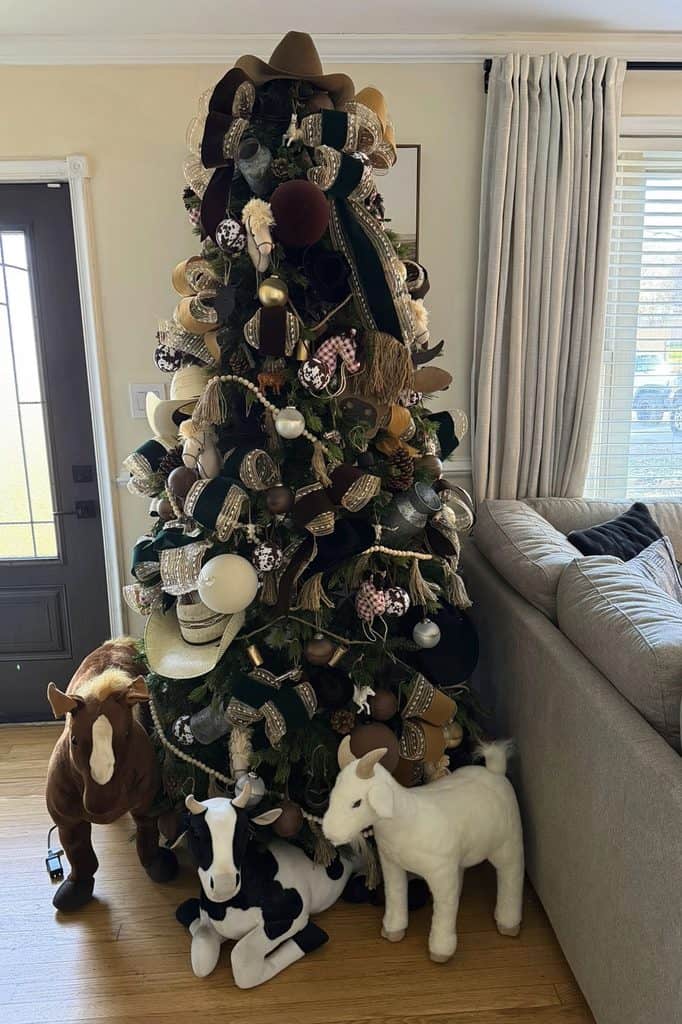 Decorated Christmas tree with plush animal toys and ornaments in living room.