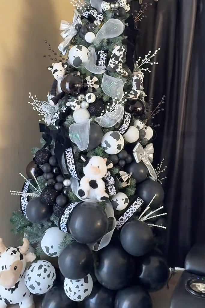 Stylish black and white Christmas tree with ornaments and ribbons for holiday decor.