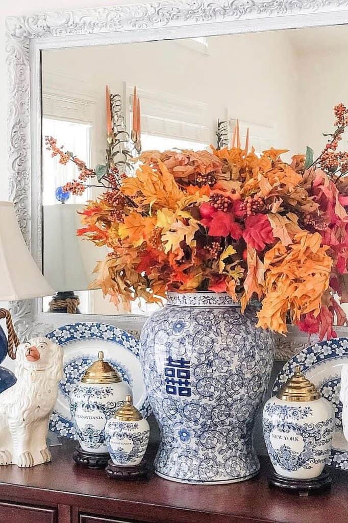 Autumn floral arrangement with blue and white decorative vases for fall decor.