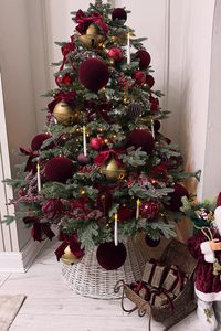 Christmas tree decorated with burgundy and gold ornaments for holiday decor.