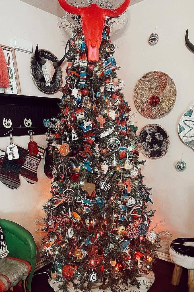 Decorated Christmas tree with animal antlers and eclectic ornaments for holiday decor.
