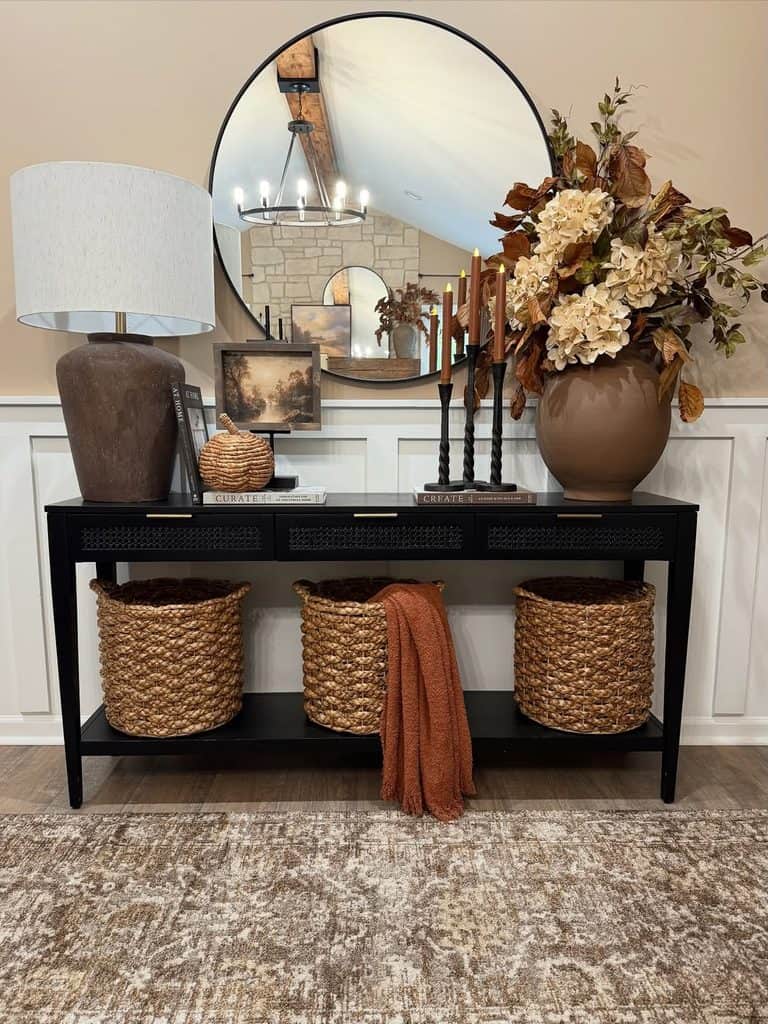Elegant fall decor with flowers, candles, and a mirror in a cozy entryway.