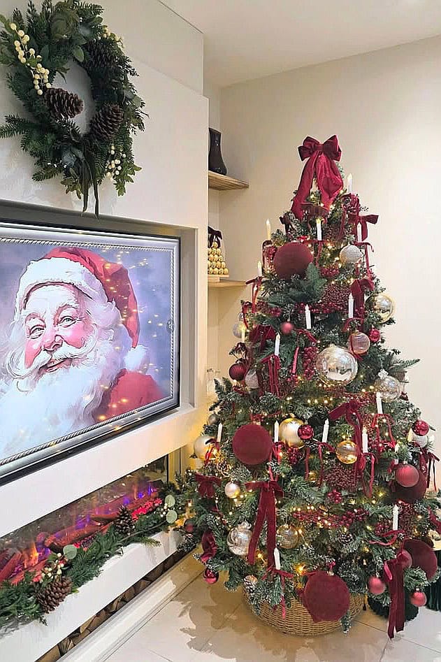 Decorated Christmas tree with red baubles, ribbons, and ornaments for holiday cheer.