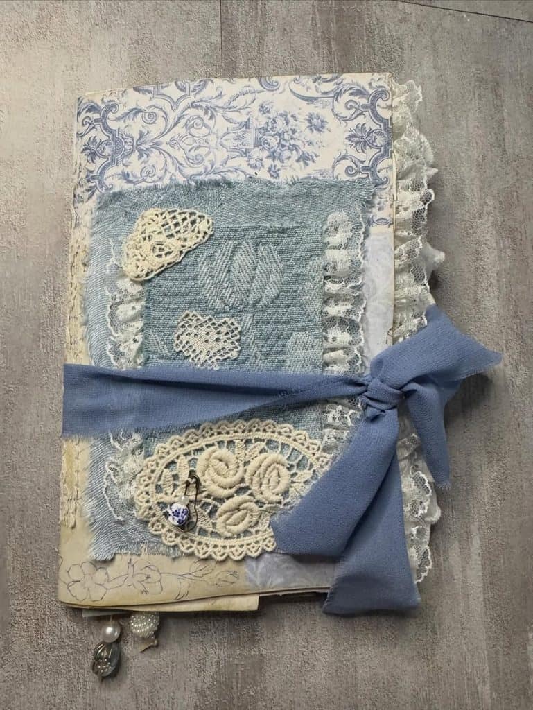 Vintage doily journal cover with lace, ribbon, and crochet embellishments.