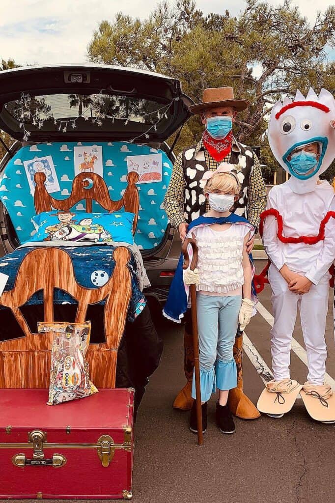 Children and adults in Toy Story costumes at trunk or treat event.