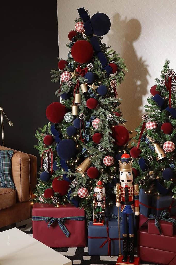Decorated Christmas tree with red, blue, and gold ornaments and nutcracker figures.