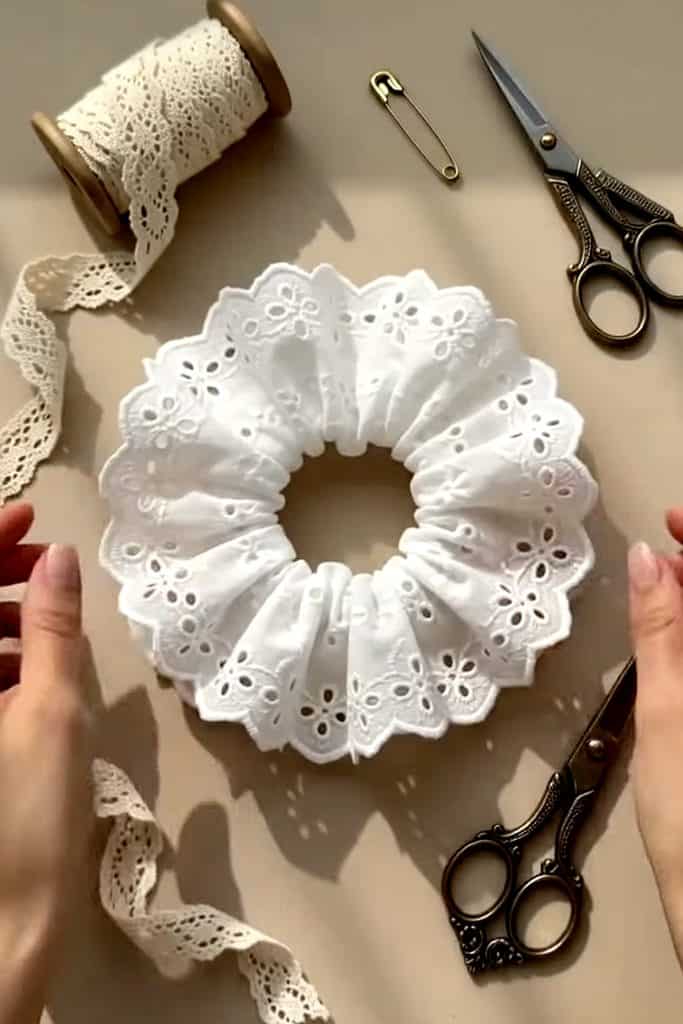 Creating a decorative hair tie using white embroidered doilies and sewing tools.