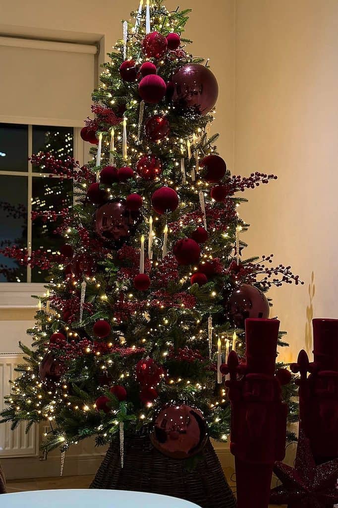 Beautiful Christmas tree decorated with burgundy ornaments and warm lights.