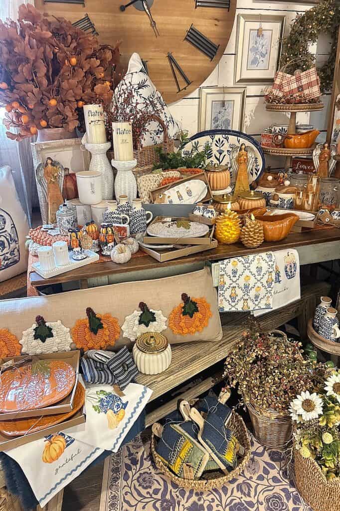 Elegant fall decor featuring blue and orange accents, pumpkins, and seasonal accessories.