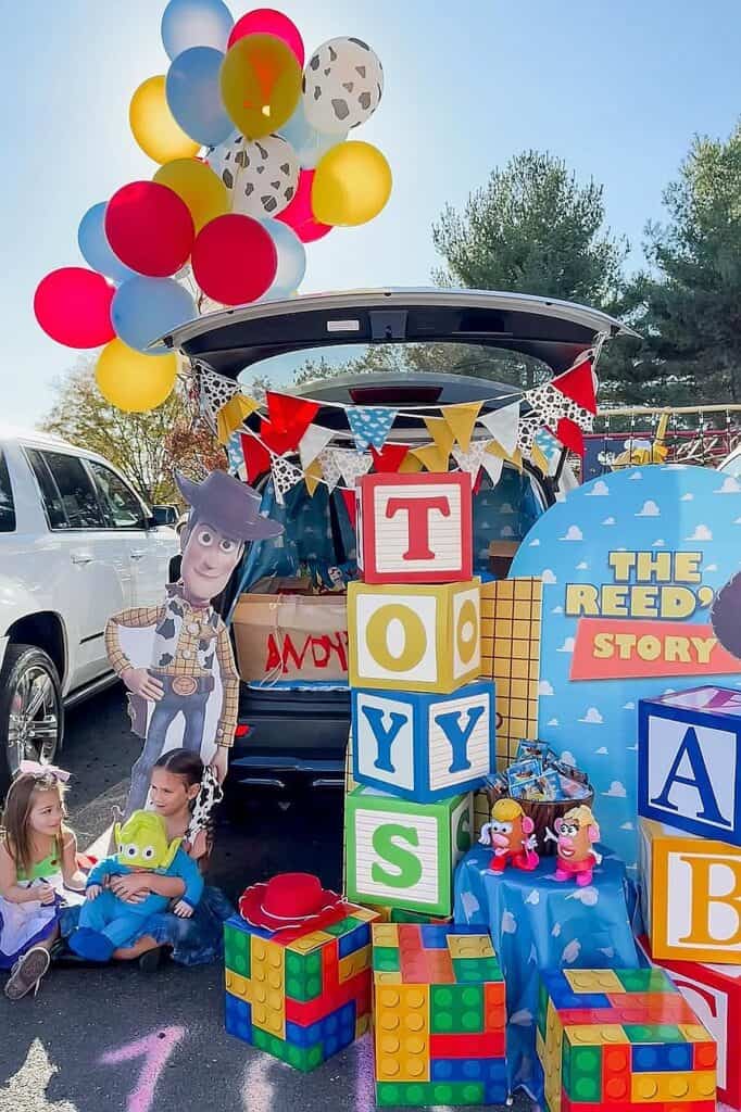 Colorful Toy Story themed trunk or treat setup with balloons and toys.