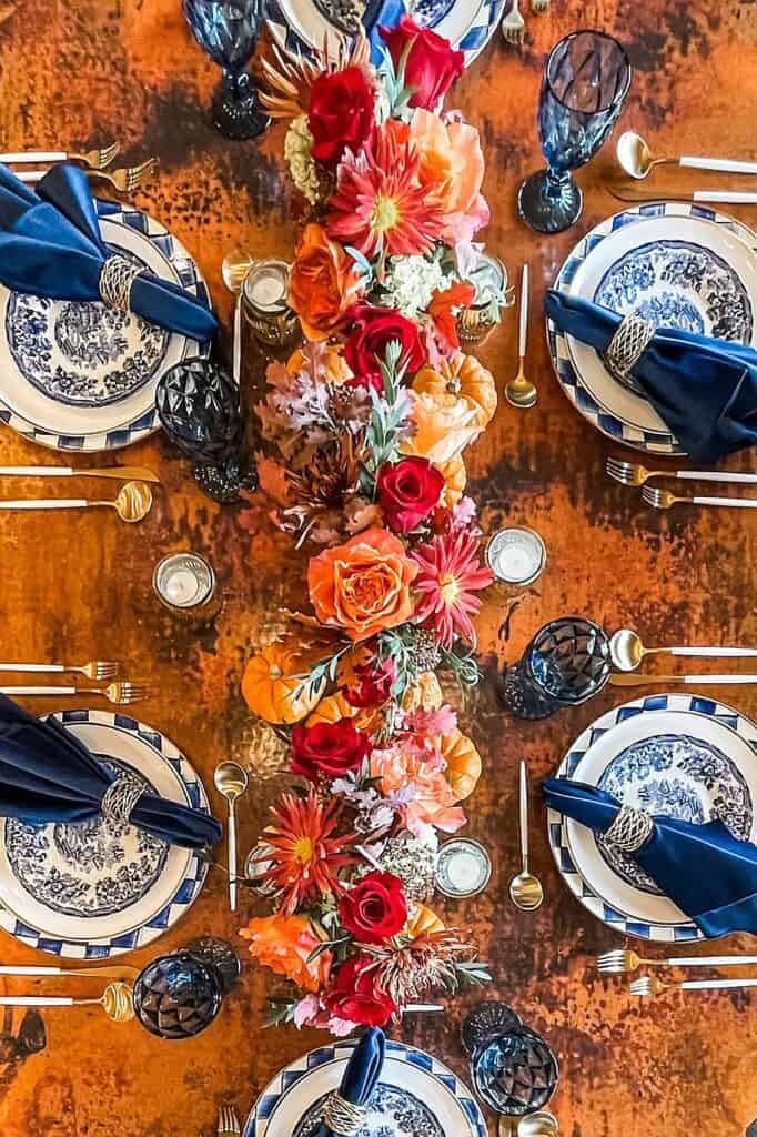 Vibrant fall floral centerpiece with orange, red, and pink flowers for autumn decor.