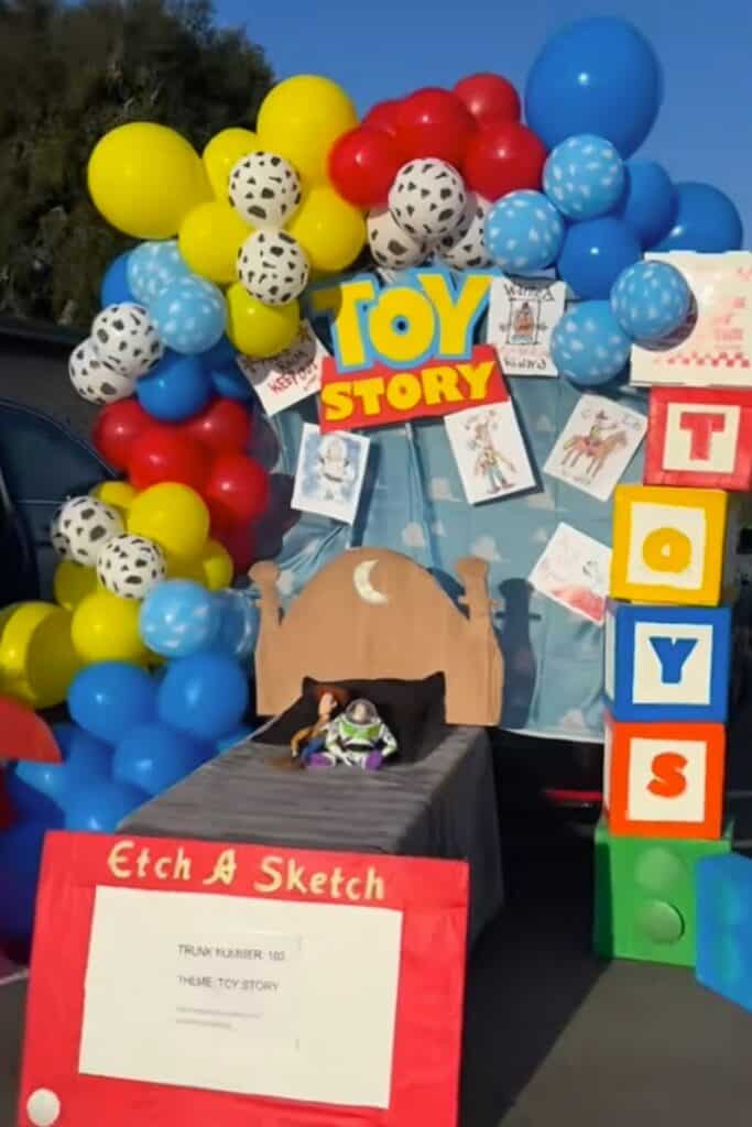 Colorful Toy Story themed trunk or treat display with balloons and character blocks.