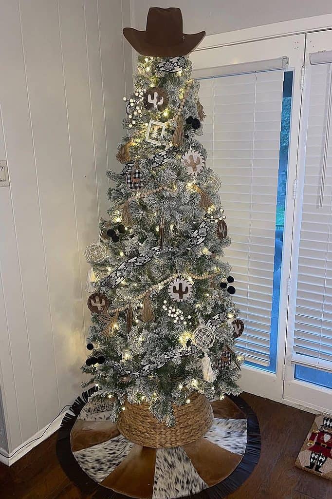 Festive Christmas tree with cowboy hat, ornaments, and lights in Western style.