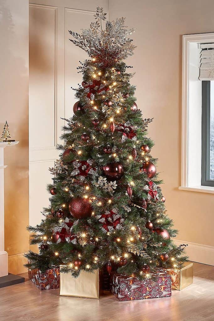 Beautiful Christmas tree decorated with burgundy ornaments and lights in a cozy home.