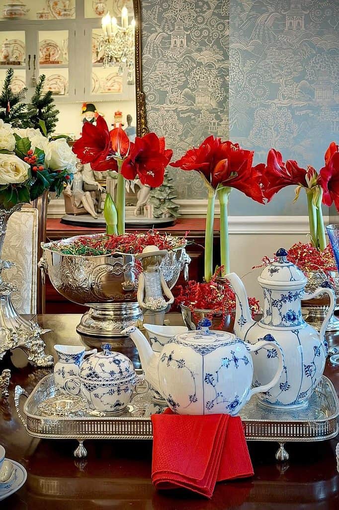 Festive Christmas tea set with red flowers and holiday decor.