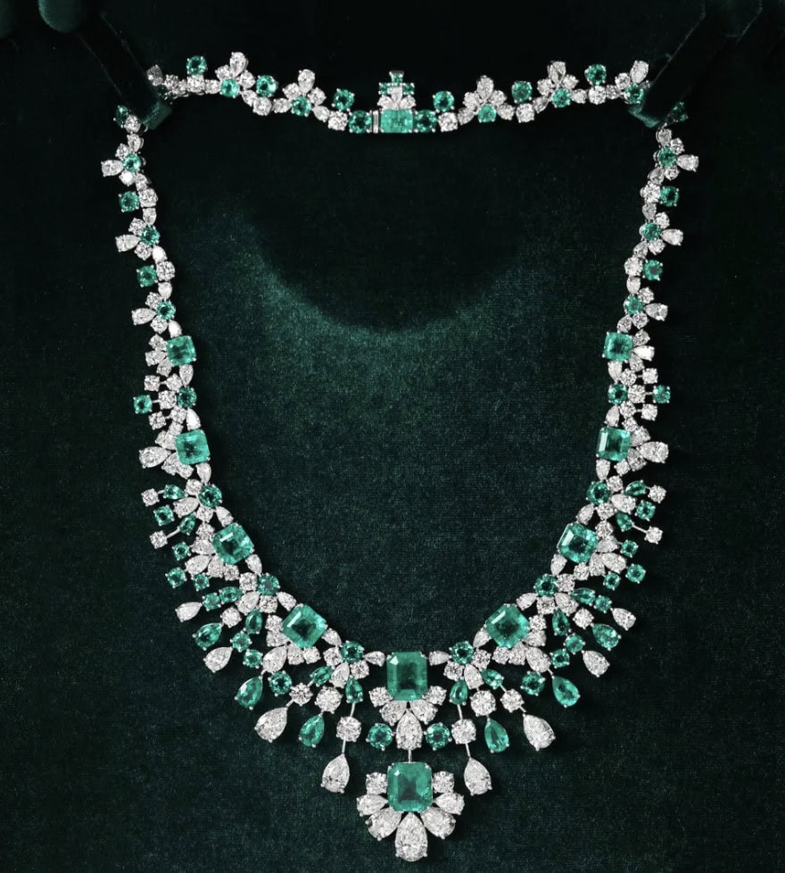 Luxurious emerald and diamond jewelry necklace on black background.