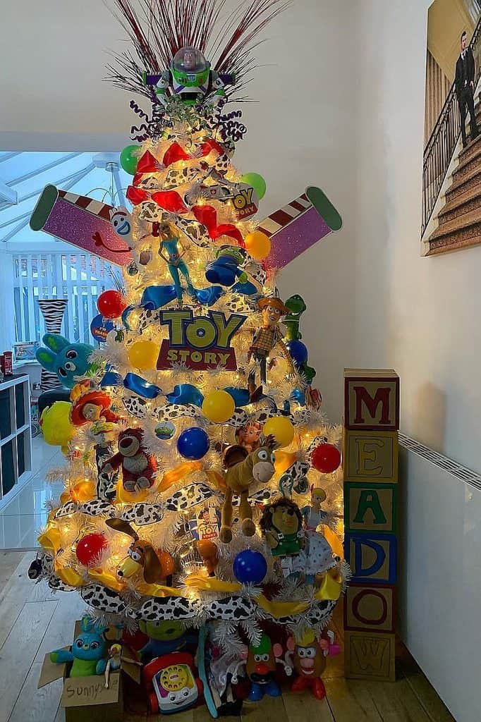 Colorful Toy Story themed Christmas tree with plush toys and lights.