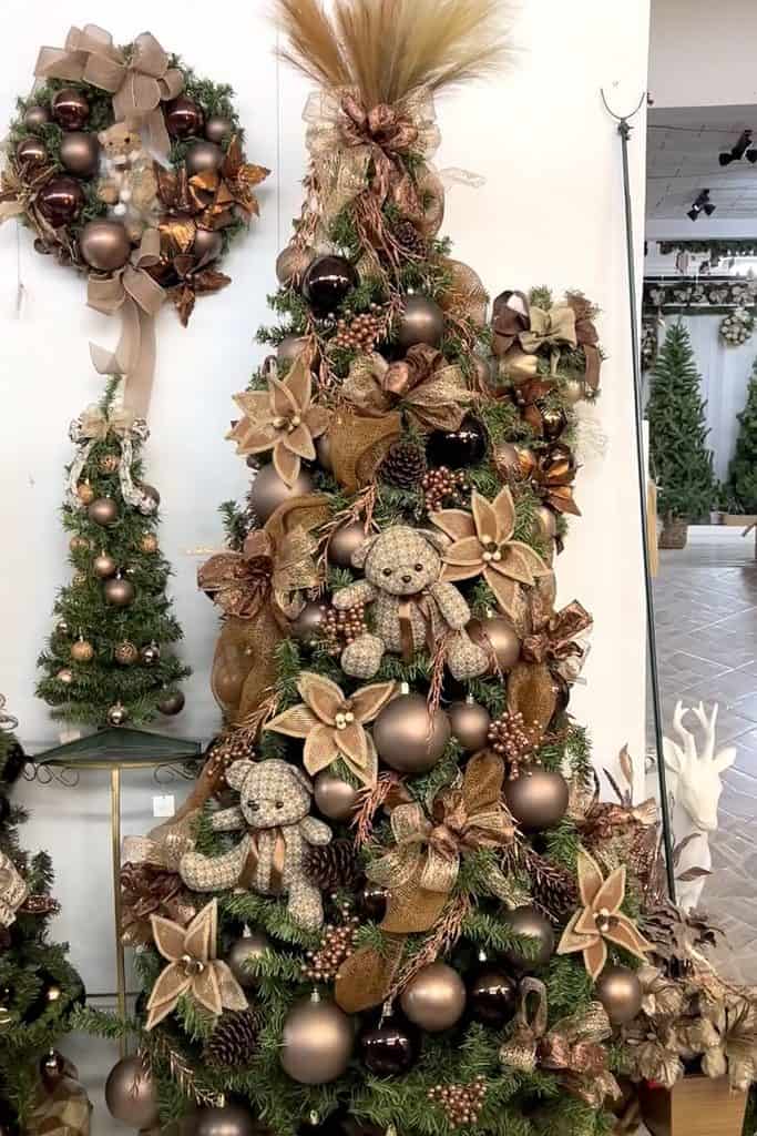 Beautiful brown-themed Christmas tree with ornaments, bows, and plush toys.