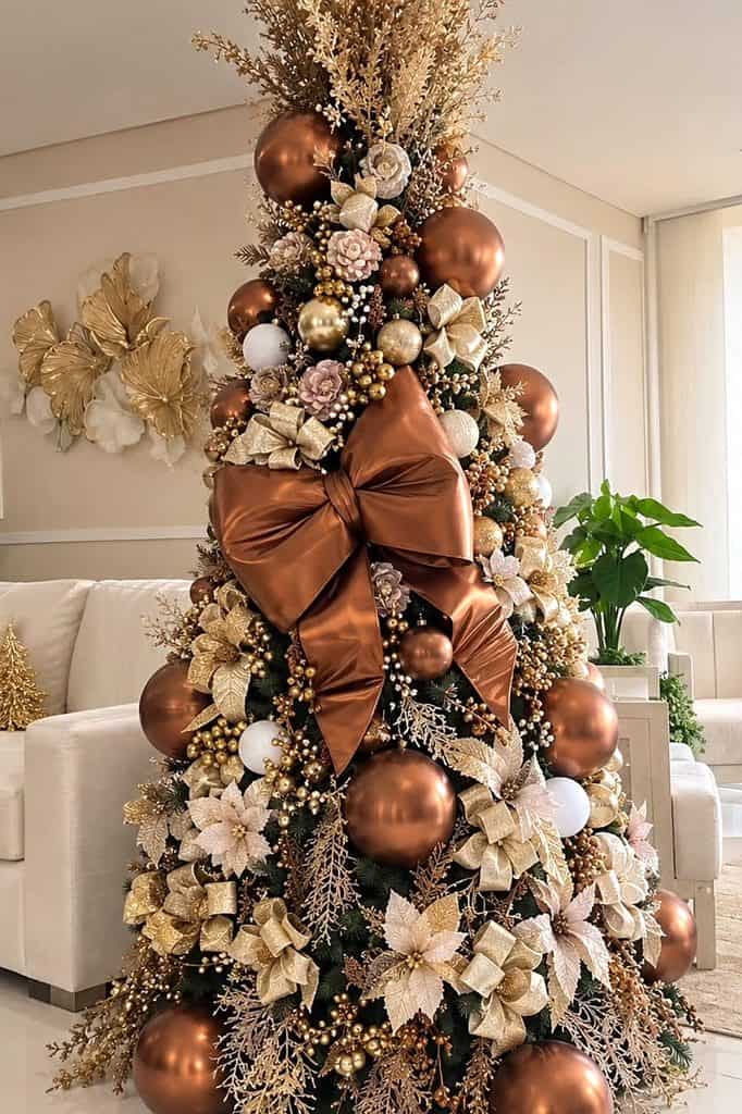Beautiful brown Christmas tree with gold and white ornaments and a large bow.