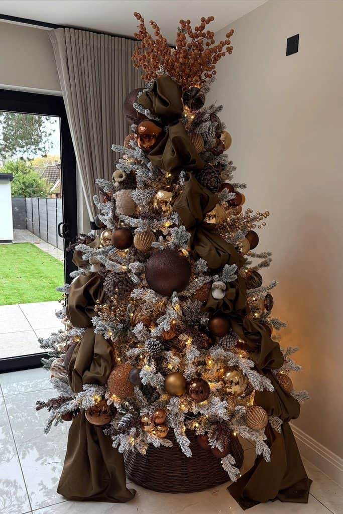 Cozy brown Christmas tree decorated with gold and bronze ornaments and ribbons.