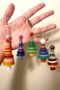 Hand holding colorful button Christmas ornaments for holiday decor.