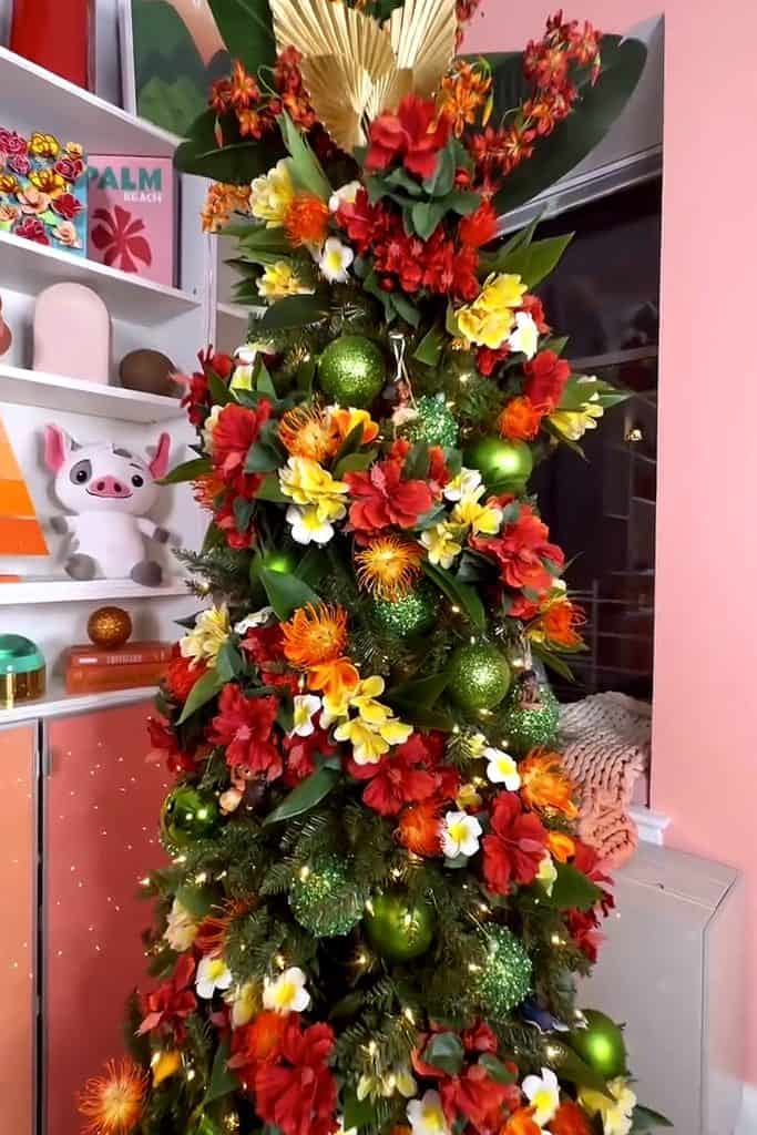 Colorful Christmas tree decorated with red, green, and yellow ornaments and flowers.
