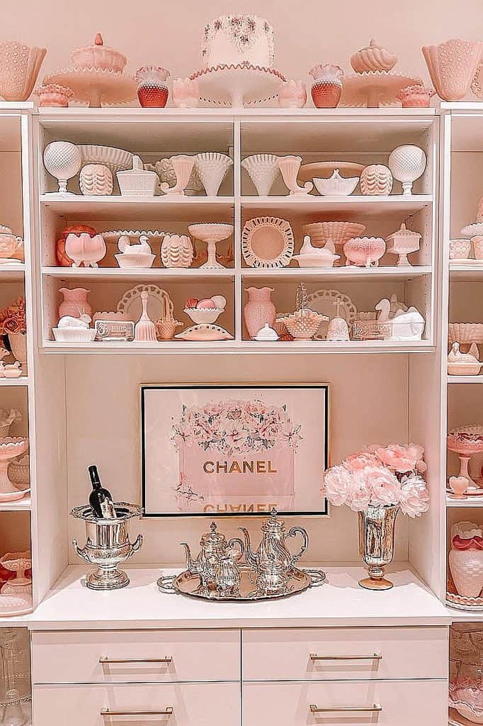 Elegant pink milk glass collection with vintage decor and flowers.