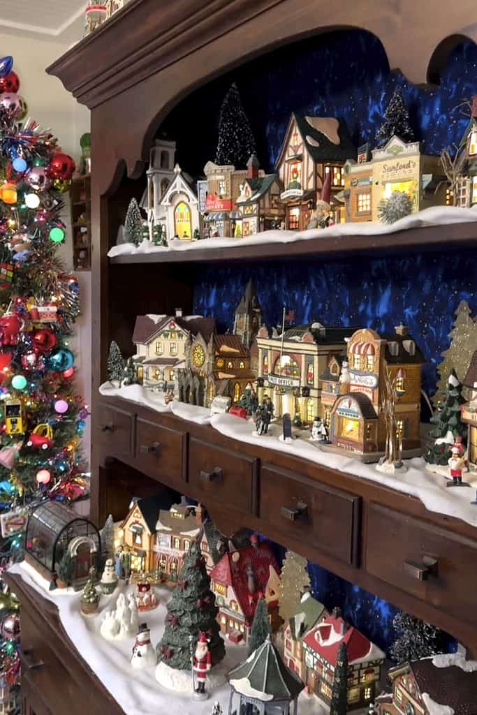 Festive Christmas village display with decorated houses and snow accents.