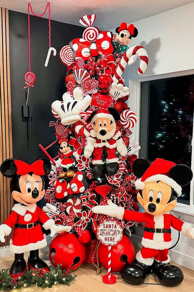 Festive Disney Christmas tree decorated with Mickey and Minnie Mouse in holiday costumes.