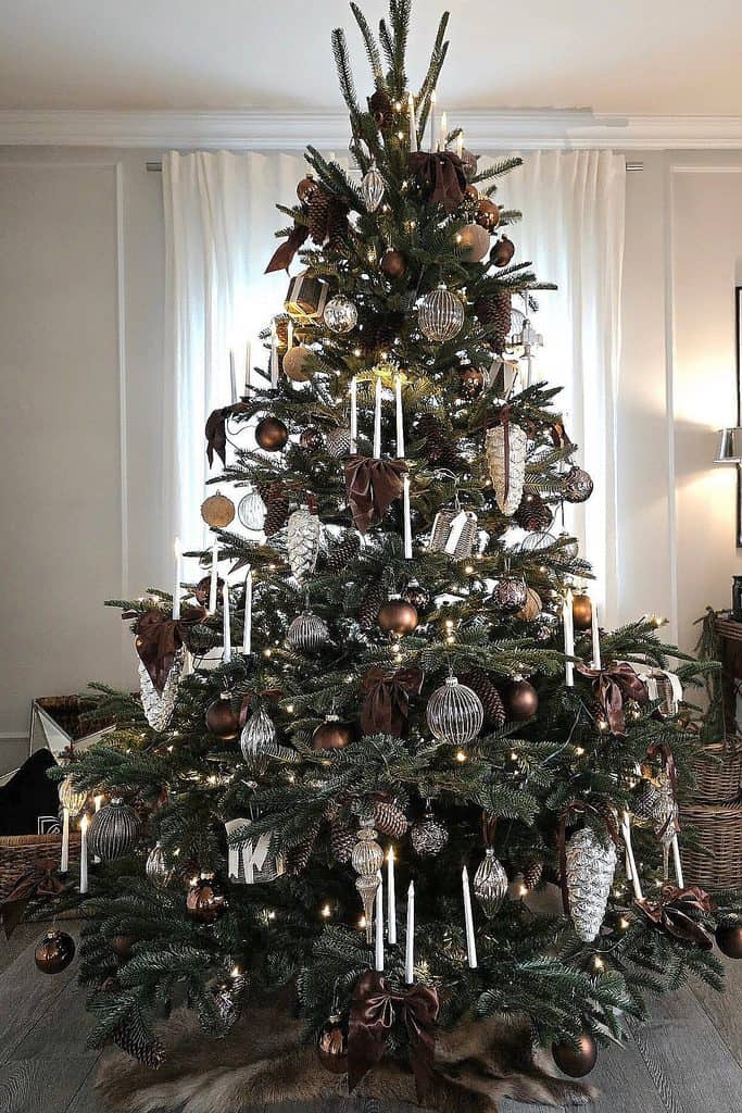 Beautiful brown-themed Christmas tree with ornaments and candles for cozy holiday decor.