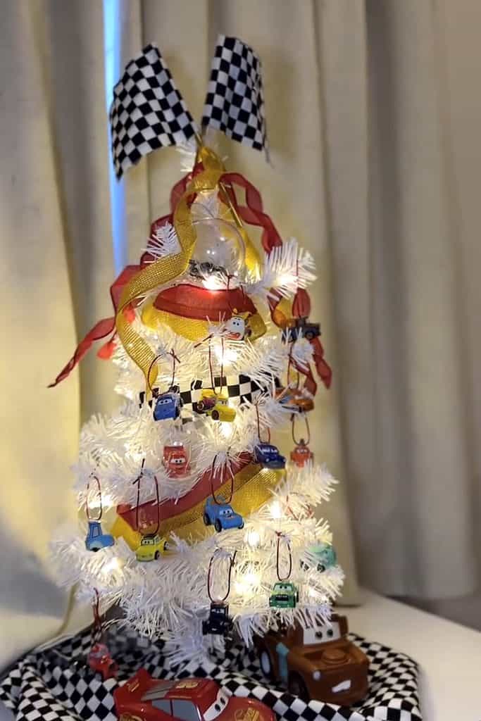 Miniature Disney Cars themed Christmas tree with checkered ribbons and car ornaments.