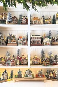 Festive Christmas village with decorated houses and snow-covered trees.